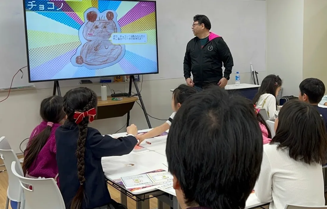 大画面に映った、子どもが描いた絵から生まれたキャラクターをみんなで楽しむ様子